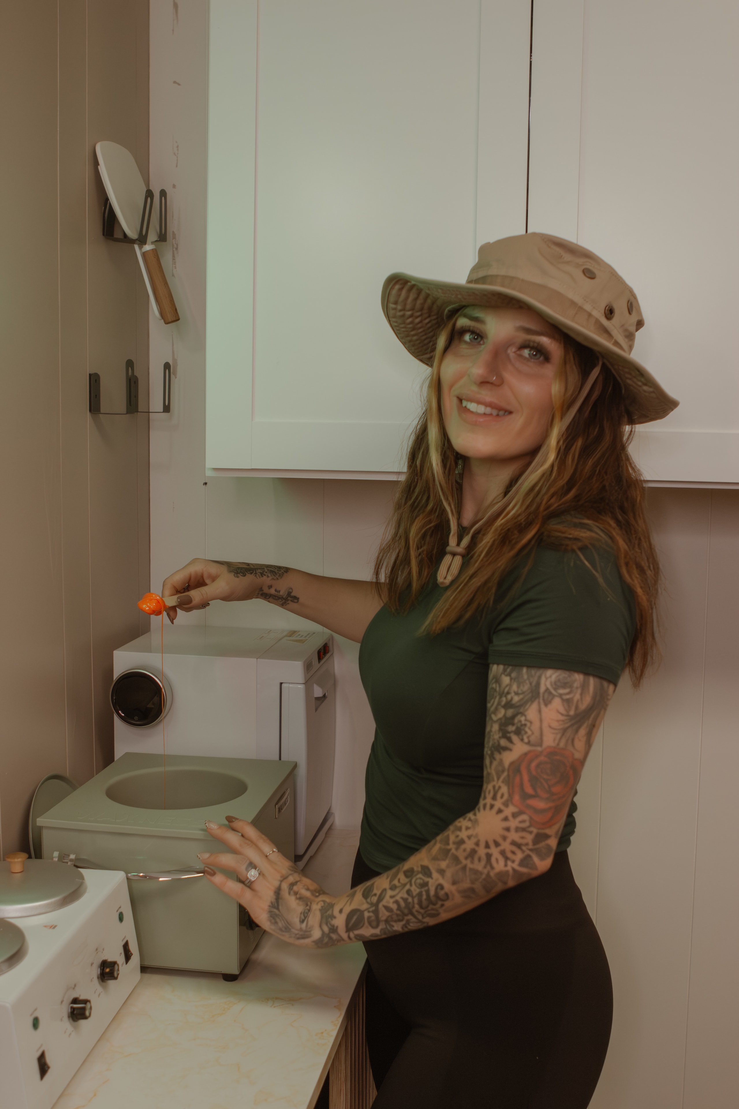 The esthetician at The Lyvenik Lounge, working with wax warmer in the studio